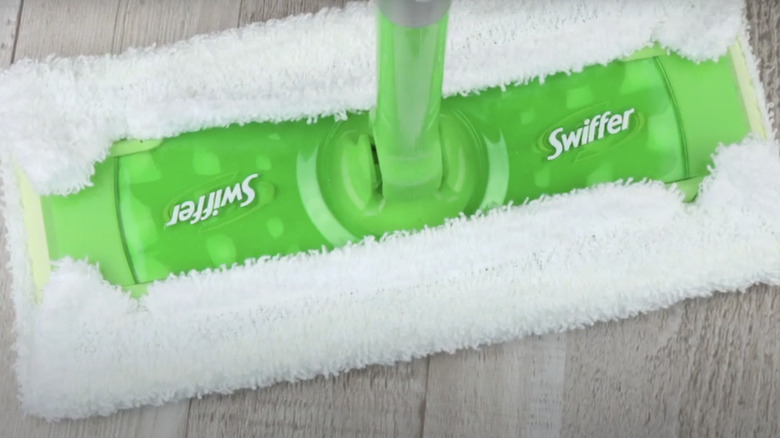 Reusable mop cloth made from old towel on a bathroom mop.