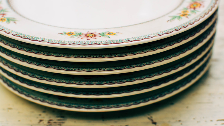 Stacked dinner plates with yellow and pink flowers on the rim