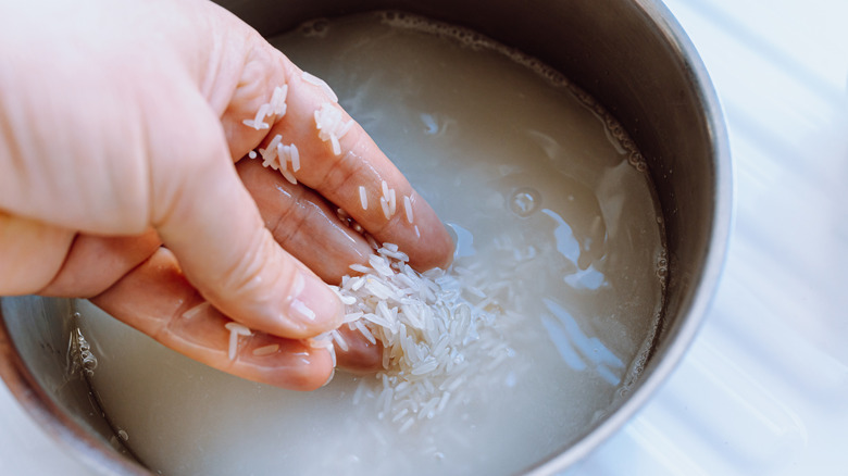 A person washing rice in a bowl