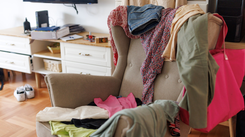 Several articles of clothing draped on an upholstered chair