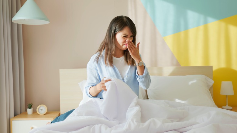 woman repulsed by smelly duvet