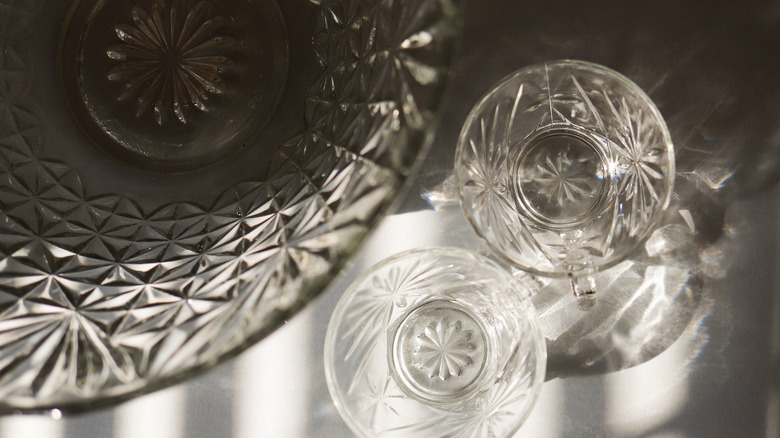 cut glass punch bowl with two punch glasses on a stainless steel table