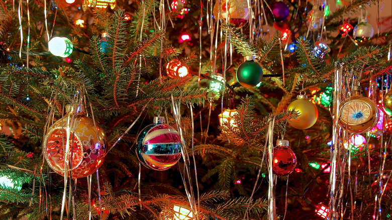 ornaments, tinsel and lights on a christmas tree