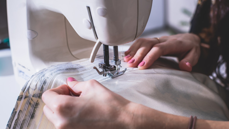 close up of person sewing fabric with sewing machine