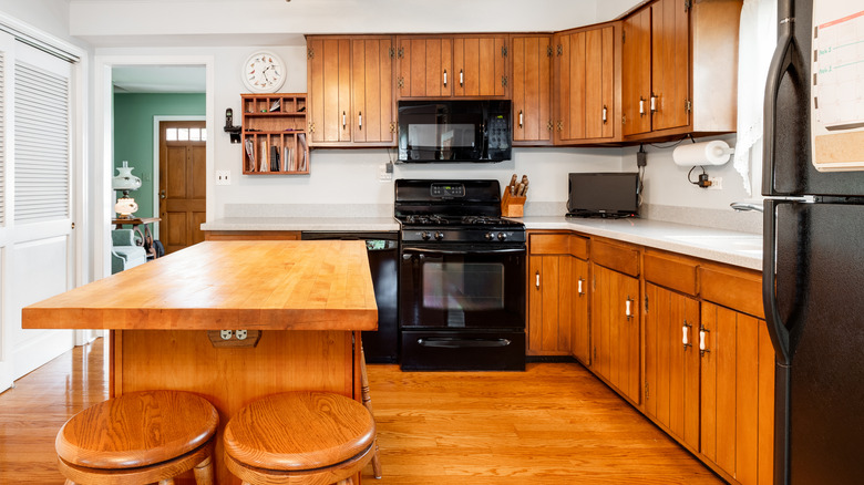 Old brown cabinets in an empty kitchen