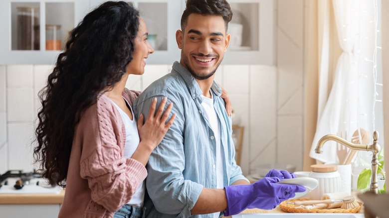 couple with man washing dishes