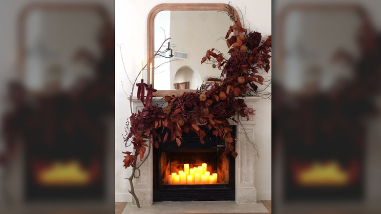 Branching fall leaves draped over a fireplace mantel