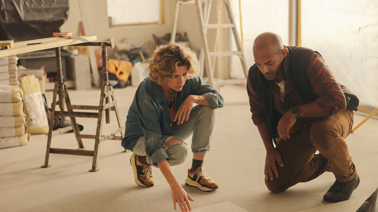 A couple in a partly renovated room discussing floor renovation
