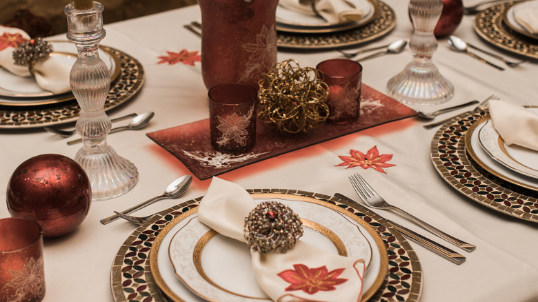 Elegant holiday place settings with an embroidered tablecloth and napkins