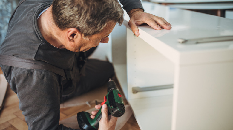 man assembles furniture