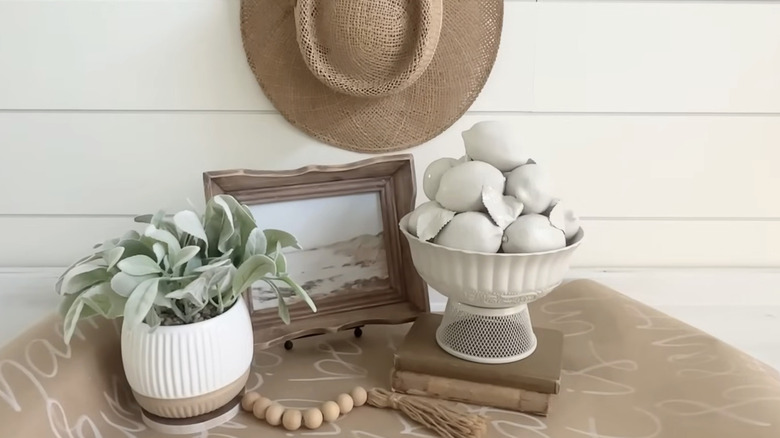 A boho farmhouse table with a bowl of white painted lemons.
