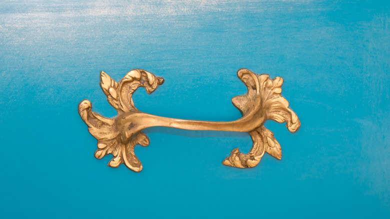 Gold scrolled leaf pull on blue drawer