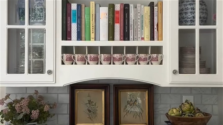 books vertically lined in upper kitchen cabinet