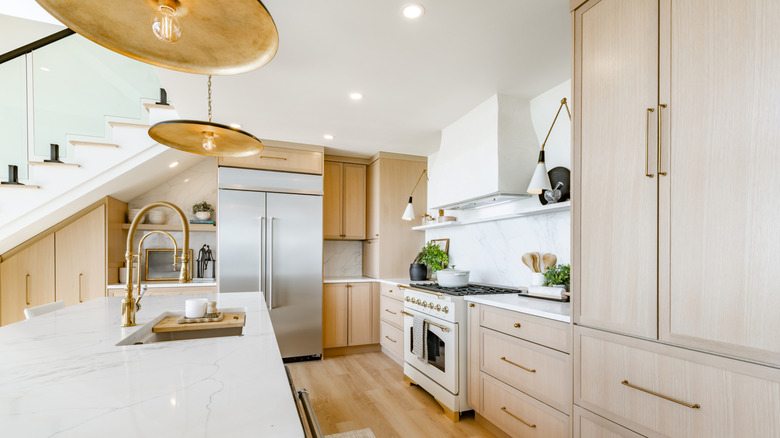 A modern kitchen fitted with brass tap and fixtures