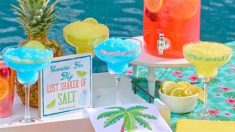 Margaritaville themed merchandise and drinks in a poolside arrangement.