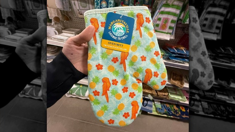 Hand holding up a tropical printed oven mitt