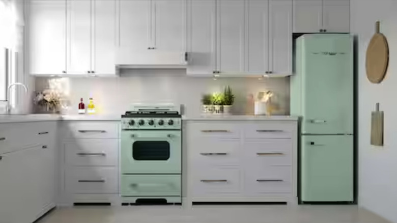 An L-shaped kitchen with white cabinets and a mint green oven and fridge.