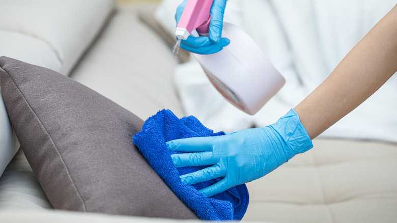 person cleaning throw cushions