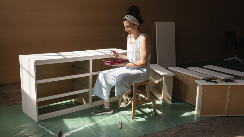 woman painting dresser