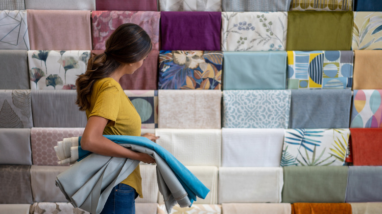 A person looking at different fabrics in a store