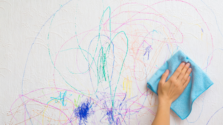 Close up of person wiping off marker from white wall