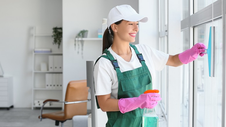 Woman using a squeegee on a shower door