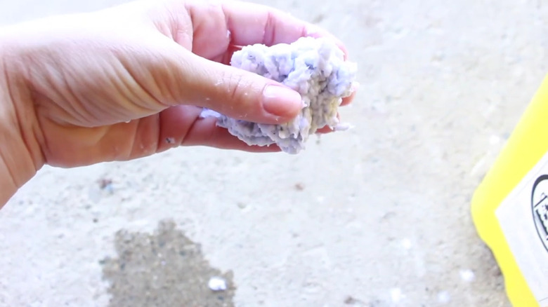 A hand holding a ball of paper pulp.