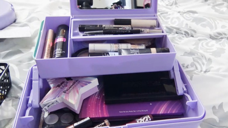 A purple Caboodle case is well stocked with makeup.