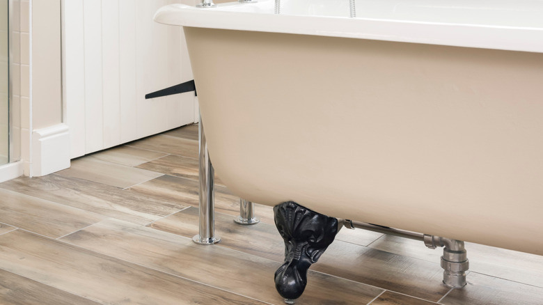 A beige bathtub with claw feet.