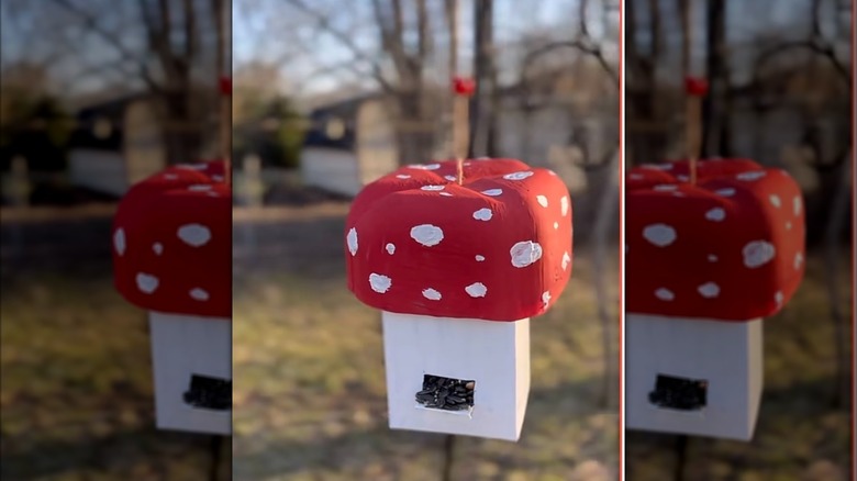 A homemade mushroom-shaped bird feeder made from milk containers.