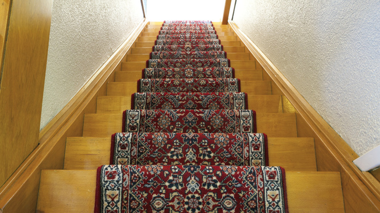 Bird's eye view of wooden staircase with a patterned runner