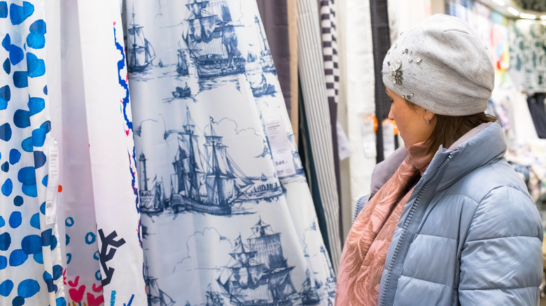 A woman shopping for shower curtains in a store