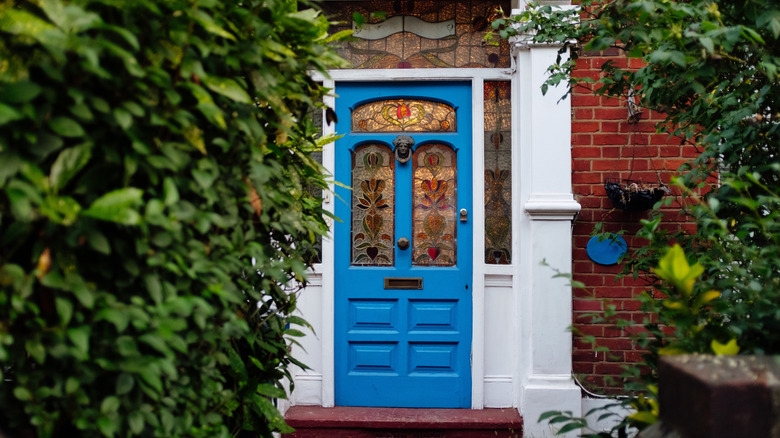 A blue door with stained glass windows.