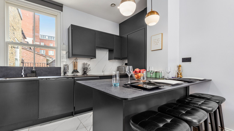 A modern kitchen with a large backsplash and thin countertops