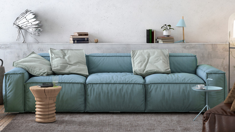 A blue couch with three, big cushions