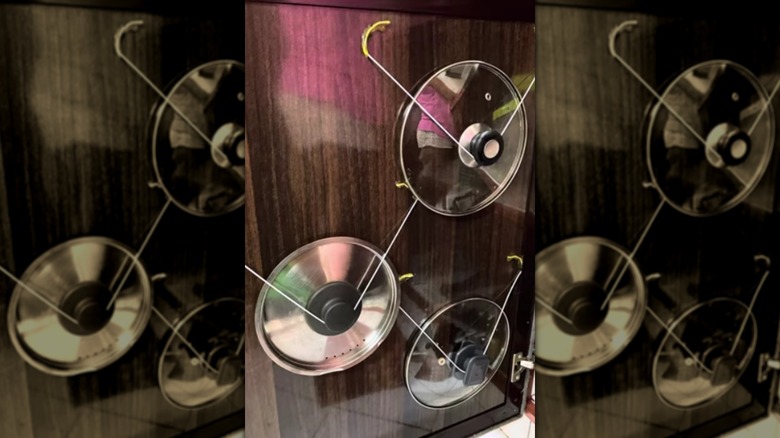 Pot lids hanging on repurposed wire coat hangers