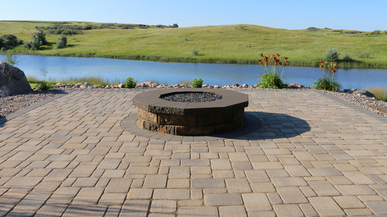 A patio area made from composite pavers featuring a large fire pit