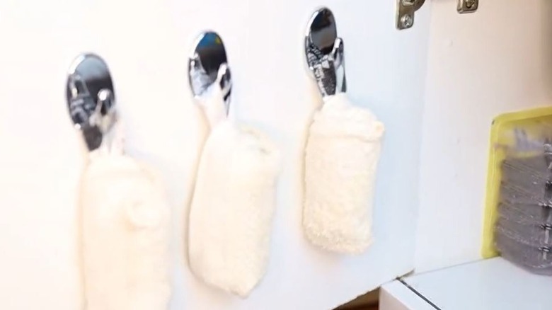 Folded dish towels hung underneath sink