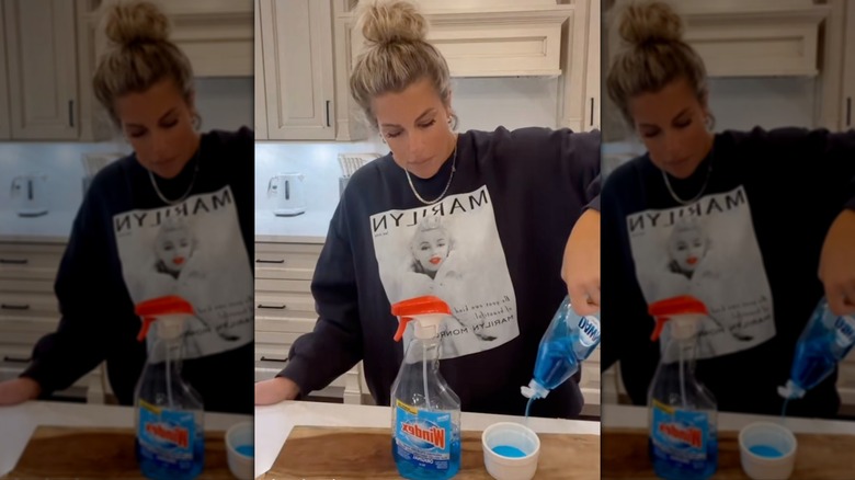 Woman mixing Dawn dish soap and Windex with water to make a jewelry cleaner.