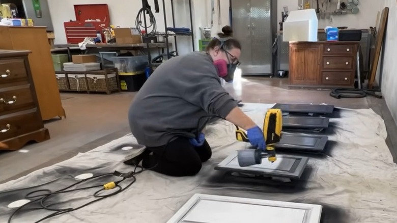Woman painting cabinet doors in blue