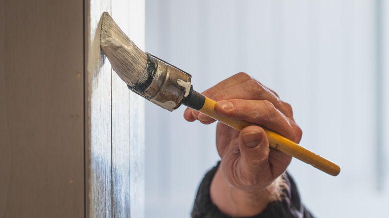 Person painting a kitchen cabinet