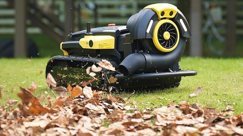 A robotic leaf blower blowing away leaves in a yard