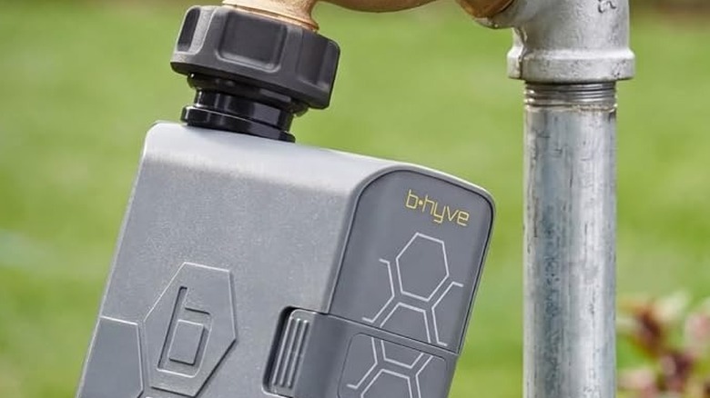A closeup of a watering timer hooked up to a hose