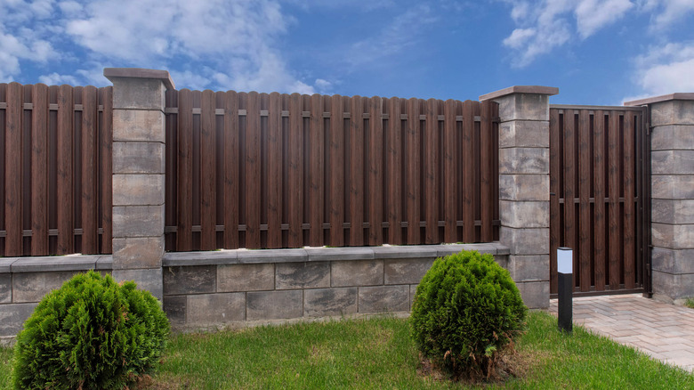 Stone and wood privacy fence around yard.