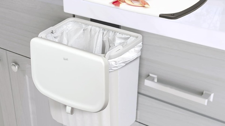 Glad over-the-door trash can temporarily hanging outside of the cabinet to catch waste from the cutting board above it