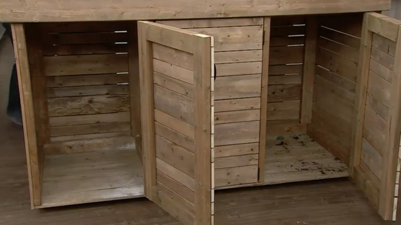 The interior of the outdoor trash bin cabinet showing frame and board construction
