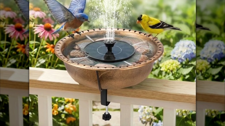 A round deck-mounted bird bath with a solar fountain and two birds perched on the edges.