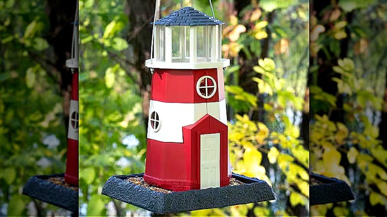 A red and white lighthouse bird feeder