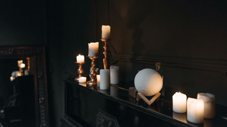 Candles on a fireplace mantel reflecting in a mirror