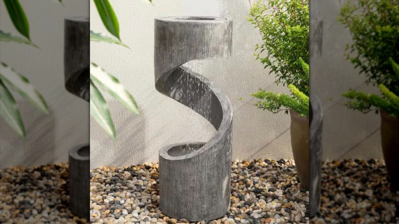 Modern fountain on pebbles in an outdoor setting